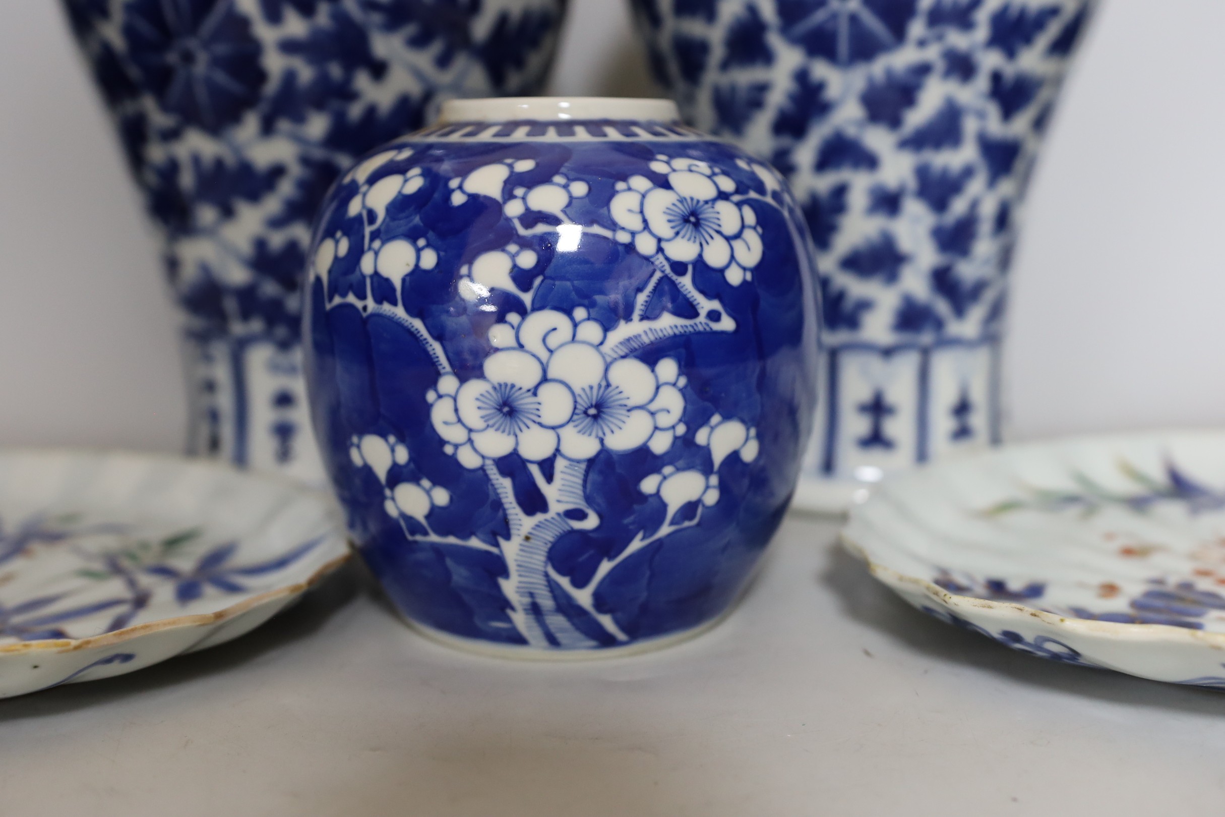 Two early 20th century Chinese blue and white vases with lion dog covers, together with a blue and white prunus jar and a pair of Japanese export flower dishes, and covers 33cm high